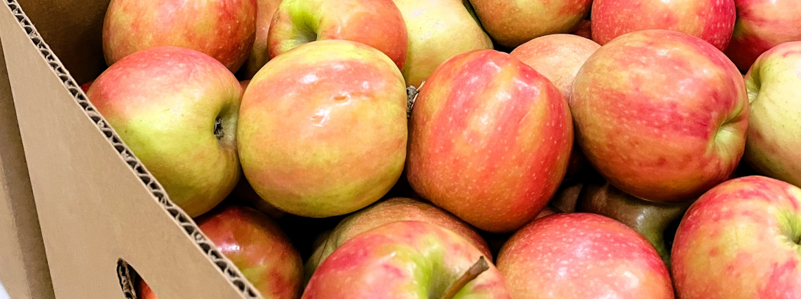 Several red apples in a cardboard box