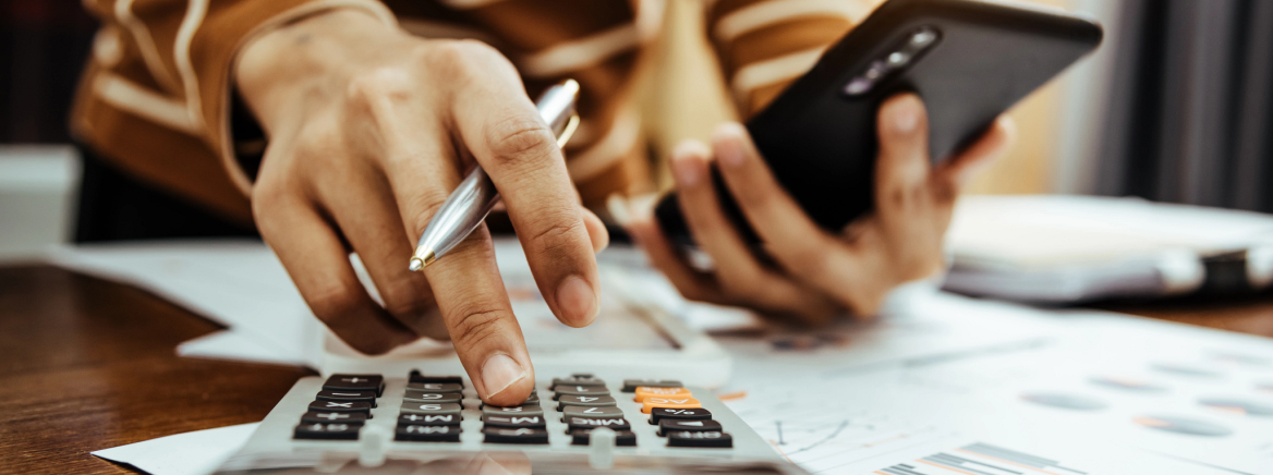 Header- Budget images of a person balancing a budget with a calculator.
