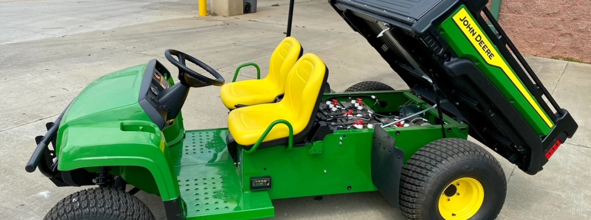 John Deere Gator A green John Deere electric Gator with yellow seats parked at Compost Central