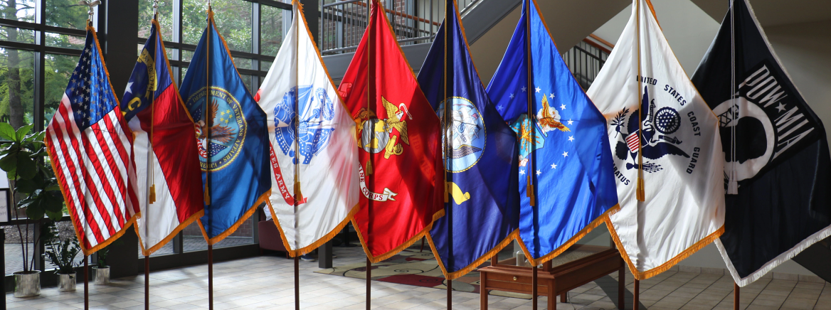 Flags United States and North Carolina flags along with various flags representing the armed forces.