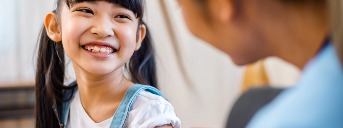 Childhood vaccination. Asian young woman doctor vaccinating little girl at home. Vaccine for covid-19 coronavirus, flu, infectious diseases.