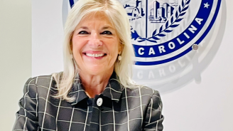 Headshot of County Manager Dena Diorio wearing a black and white blazer.