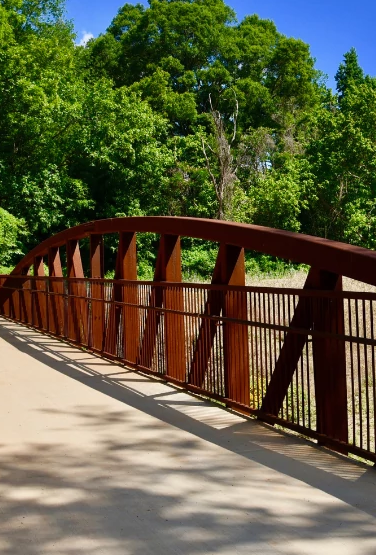A foot bridge passing over the Little Sugar Creek Greenway near Tyvola Road on a sunny day.